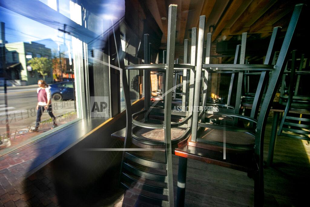 Robert F. Bukaty Chairs sit on tabletops at 3 Dollar Deweys, a pub that remains closed due to the coronavirus pandemic, Thursday, May 21, 2020, in Portland, Maine. Under Gov. Janet Mills's tentative plan, bars will be allowed to reopen on July 1. (AP Photo/Robert F. Bukaty)