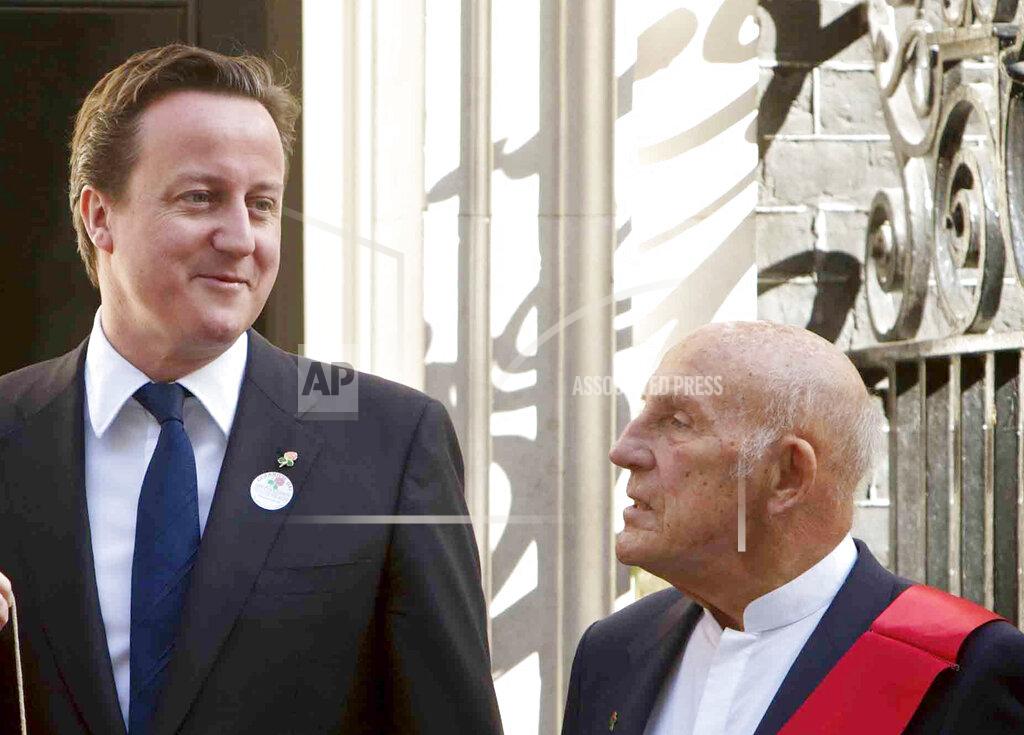 Edmond Terakopian FILE - In this file photo dated Tuesday, April 12, 2011, British Prime Minister David Cameron, left, poses for photographs with British racing driver great Stirling Moss, at 10 Downing Street, in London. Stirling Moss has died at the age of 90, according to an announcement Sunday April 12, 2020, from his family. (AP Photo/Edmond Terakopian, FILE)