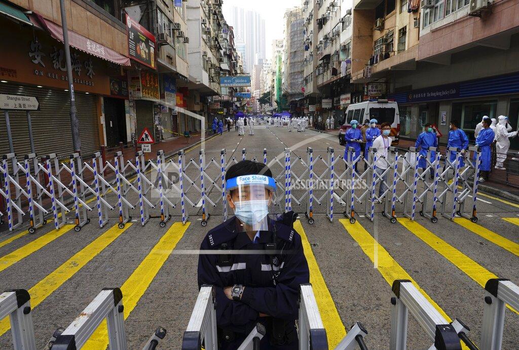 Vincent Yu A police officer stands guard at the Yau Ma Tei area, in Hong Kong, Saturday, Jan. 23, 2021. Thousands of Hong Kong residents were locked down Saturday in an unprecedented move to contain a worsening outbreak in the city, authorities said. (AP Photo/Vincent Yu)