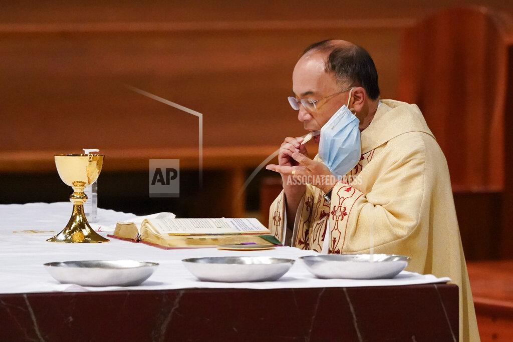 Ashley Landis Father David Gallardo removes his mask to take communion as he leads Christmas Eve Mass at Cathedral of Our Lady of the Angels Thursday, Dec 24, 2020, in Los Angeles. California became the first state to record 2 million confirmed coronavirus cases, reaching the milestone on Christmas Eve as nearly the entire state was under a strict stay-at-home order and hospitals were flooded with the largest crush of cases since the pandemic began. (AP Photo/Ashley Landis)
