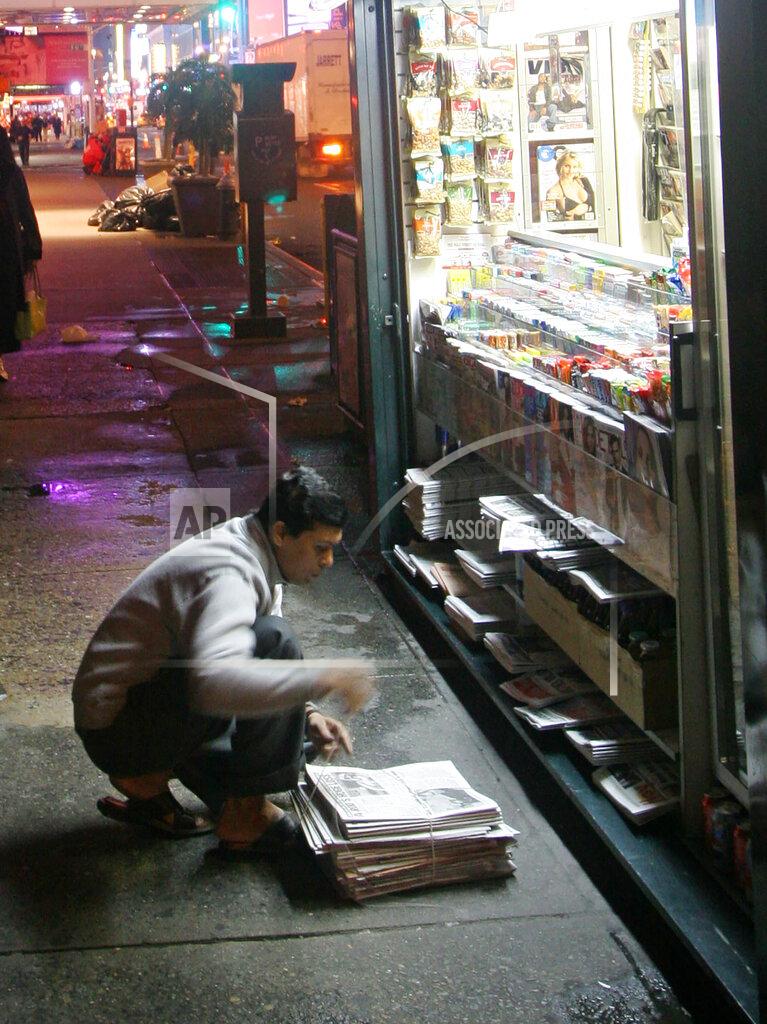 Mark Lennihan FILE - A newsstand salesman bundles unsold newspapers at his stand in New York's Times Square on Oct. 18, 2005. A report from Northwestern University says local newspapers in the United States are dying at the rate of two per week. There has been growth in digital alternatives, but not nearly enough to compensate for what has been lost. (AP Photo/Mark Lennihan, File)