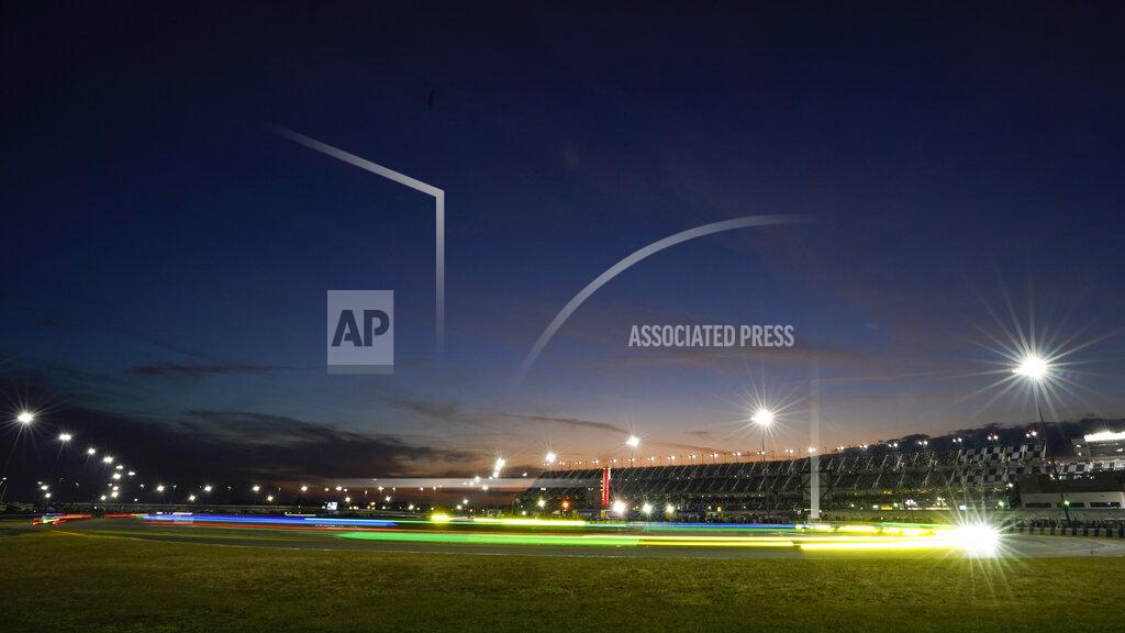 John Raoux In this image taken with a slow shutter speed, cars leave a light streak as they drive through the east horseshoe turn during the Rolex 24 hour auto race at Daytona International Speedway, Saturday, Jan. 30, 2021, in Daytona Beach, Fla. (AP Photo/John Raoux)