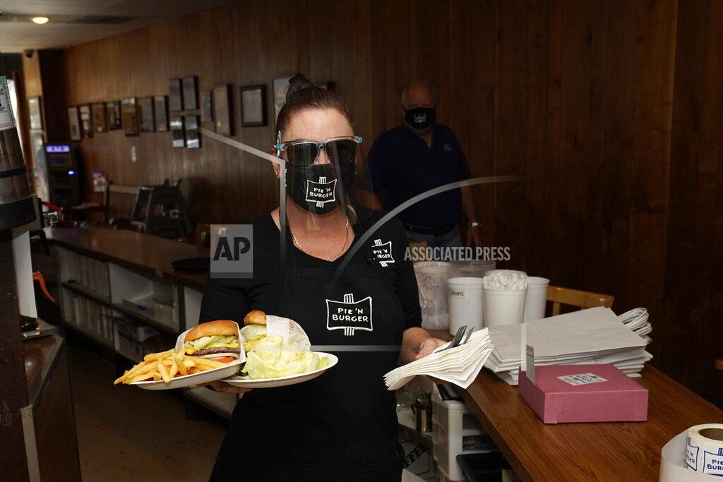 Marcio Jose Sanchez *** Hold For Story *** A waitress serves lunch Tuesday, Dec. 1, 2020, at Pie 'N Burger in Pasadena, Calif. Pasadena has become an island in the center of the nation's most populous county, where a surge of COVID-19 cases last week led to a three-week end to outdoor dining and California's first stay-home order since the pandemic began to spread across the state in March. (AP Photo/Marcio Jose Sanchez)