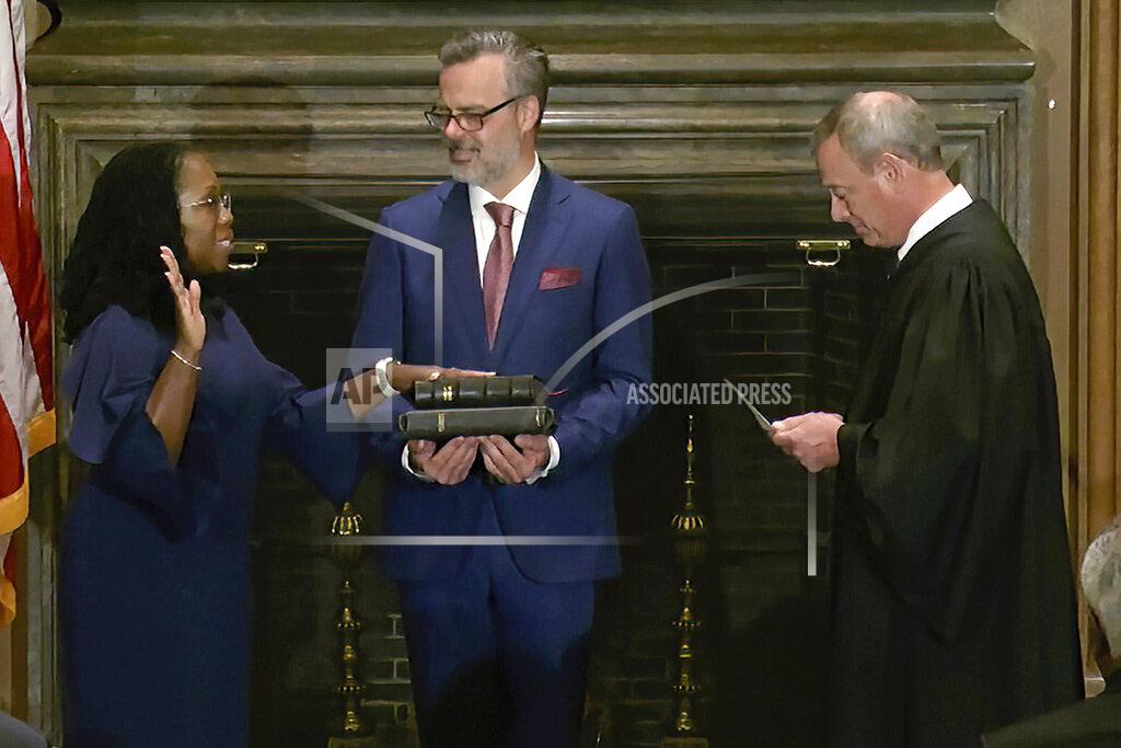 Uncredited In this image from video provided by the Supreme Court, Chief Justice of the United States John Roberts administers the Constitutional Oath to Ketanji Brown Jackson as her husband Patrick Jackson holds the Bible at the Supreme Court in Washington, Thursday, June 30, 2022. (Supreme Court via AP)