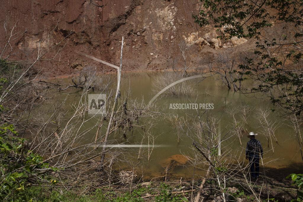 Rodrigo Abd Julio Villanueva Melgar, 70, stands on the edge of a lagoon created when heavy rains caused by the November 2020 Hurricanes Eta and Iota triggered a mudslide in La Reina village, Honduras, Wednesday, Sunday, June 20, 2021. More than 1,000 people are stranded in the valley marked by the poverty and drug violence that have driven so many Hondurans to the United States. (AP Photo/Rodrigo Abd)