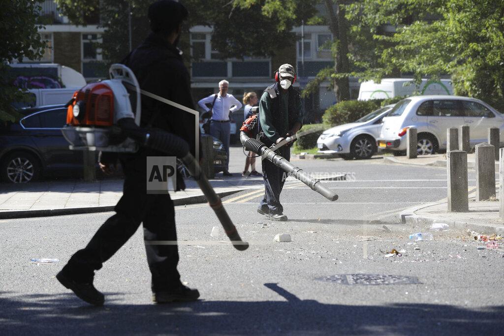 Jonathan Brady Volunteers clean up the streets following overnight violent confrontations with police, in the Brixton area of London, Thursday June 25, 2020. Authorities have reported some fifteen officers were injured and four people were arrested following the incident. (Jonathan Brady/PA via AP)