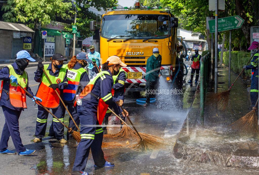 Gemunu Amarasinghe Sanitation workers in protective masks to help curb the spread of the new coronavirus use a water source to wash a street and a sidewalk in Bangkok, Thailand, Tuesday, April 28, 2020. A month-long state of emergency remains enforced in Thailand to allow its government to impose stricter measures to control the coronavirus that has infected hundreds of people in the Southeast Asian country. (AP Photo/Gemunu Amarasinghe)