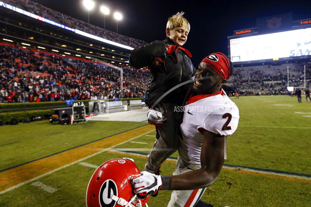 Butch Dill Georgia defensive back Richard LeCounte (2) holds up Andrew Smart, son of Kirby Smart, after the team defeated Auburn 21-14 in an NCAA college football game, Saturday, Nov. 16, 2019, in Auburn, Ala. (AP Photo/Butch Dill)