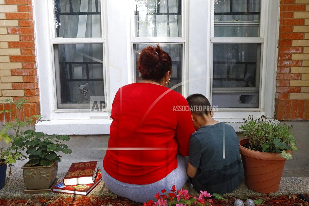 Shafkat Anowar Eugenia Rodriguez shares a moment with her youngest son, Aaron, 6, while reading a children's book Friday, July 2, 2021, in Chicago's Little Village neighborhood. Rodriguez hasn't been eligible for insurance coverage after overstaying a visitor visa from Mexico. She used to wake up every two or three hours at night to check on her mother. Since getting health insurance through the Illinois program, her mother has all the medications she needs. (AP Photo/Shafkat Anowar)
