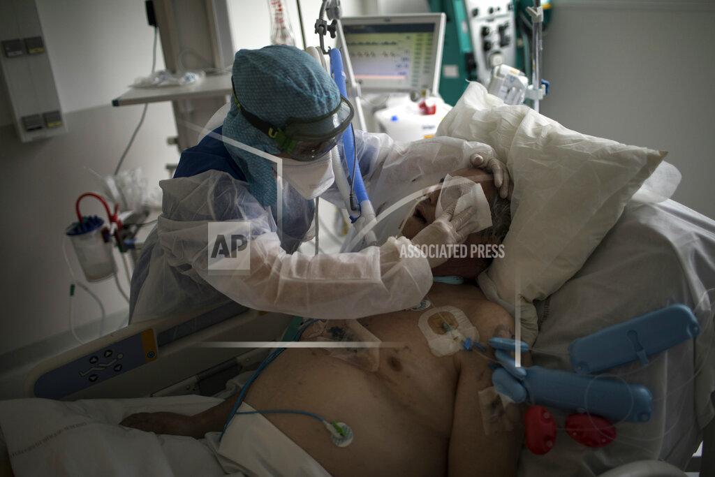 Daniel Cole A nurse cleans a patient suffering from COVID-19 in the ICU at the La Timone hospital in Marseille, southern France, Tuesday Feb. 2, 2021. COVID patients occupy 88% of the Marseille region's intensive care beds, and virus pressure on French hospitals is steadily rising in recent weeks despite curfews and other restrictions. (AP Photo/Daniel Cole)