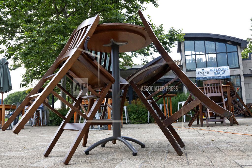 Gene J. Puskar In this July 9, 2020 file photo, tables and chairs outside the Porch restaurant in the Oakland are ready as Pittsburgh area restaurants prepare to re-open. After a year of ghostly airports, empty sports stadiums and constant Zoom meetings, growing evidence suggests that the economy is strengthening. Hiring picked up in February 2021. Business restrictions have eased as the pace of viral infections has ebbed. Yet the economy remains far from normal. (AP Photo/Gene J. Puskar)