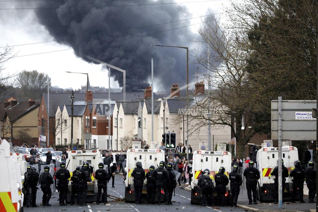 Peter Morrison FILE - In this Wednesday, April 7, 2021 file photo, police form a line on the Springfield road to stop Nationalists and Loyalists attacking each other, as a hijacked bus burns in the distance in Belfast, Northern Ireland. The chaotic scenes during a week of violence on the streets of Northern Ireland have stirred memories of decades of Catholic-Protestant conflict, known as “The Troubles.” A 1998 peace deal ended large-scale violence but did not resolve Northern Ireland’s deep-rooted tensions. (AP Photo/Peter Morrison, File)