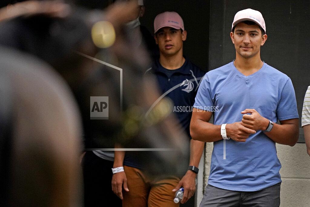 Charlie Riedel Former college teammates Dan Giovacchini, right, and Patrick O'Neill watch while Kentucky Derby entrant Hot Rod Charlie gets a bath after a workout at Churchill Downs Wednesday, April 28, 2021, in Louisville, Ky. The pair along with three other friends from college own 25% of the horse being trained by O'Neill's uncle Doug O'Neill. (AP Photo/Charlie Riedel)