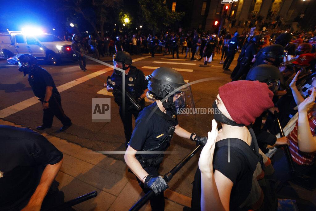 David Zalubowski A Denver police officer uses a baton to push back a protester outside the State Capitol on Thursday, May 28, 2020, in Denver, during a demonstration over the Monday death of George Floyd in Minneapolis police custody. (AP Photo/David Zalubowski)
