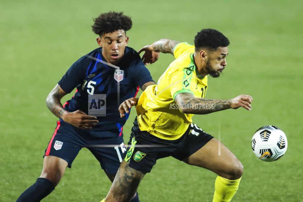 Ronald Zak USA's Chris Richards, left, duels for the ball with Jamaica's Andre Gray during the international friendly soccer match between USA and Jamaica at SC Wiener Neustadt stadium in Wiener Neustadt, Austria, Thursday, March 25, 2021. (AP Photo/Ronald Zak)