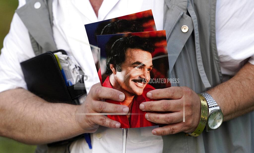 Chris Pizzello A guest holds programs during the unveiling of a memorial sculpture of the late actor Burt Reynolds at Hollywood Forever Cemetery, Monday, Sept. 20, 2021, in Los Angeles. Reynolds died in 2018 at the age of 82. (AP Photo/Chris Pizzello)