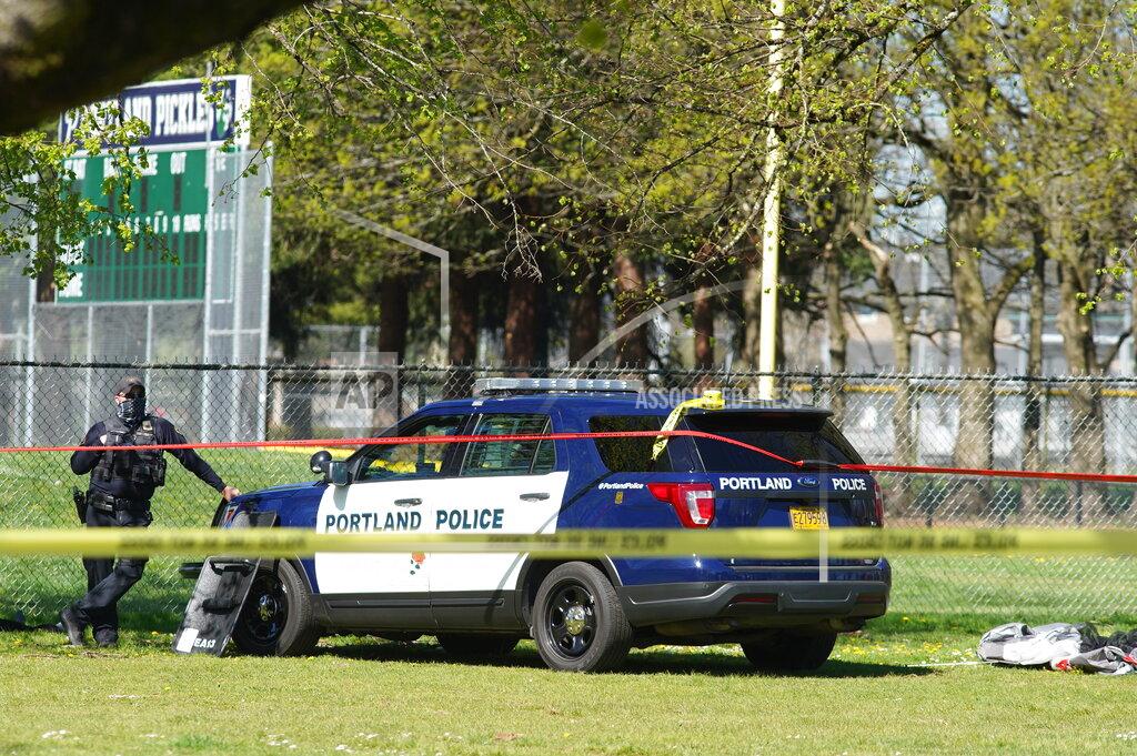 Mark Graves/The Oregonian A Portland Police officer stand by following a police involved shooting of a man at Lents Park, Friday, April 16, 2021, in Portland, Ore. Police fatally shot a man in the city park Friday morning after responding to reports of a person with a gun, authorities said. (Beth Nakamura/The Oregonian/The Oregonian via AP)