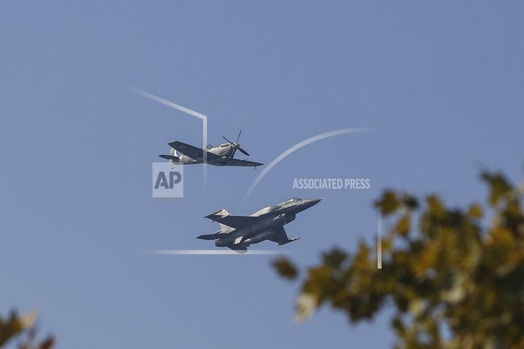 Giannis Papanikos A Hellenic Air Force F-16, right, takes part at the annual military parade next to a historic Spitfire a plane which took part in the WWII, at the northern port city of Thessaloniki, Greece, on Thursday, Oct. 28, 2021 .The parade is held to celebrate Greece's refusal to align itself with a belligerent fascist Italy in 1940 and instead fight a much stronger opponent, a decision which dragged it into World War II and eventually led to a brutal occupation by Nazi Germany. (AP Photo/Giannis Papanikos)