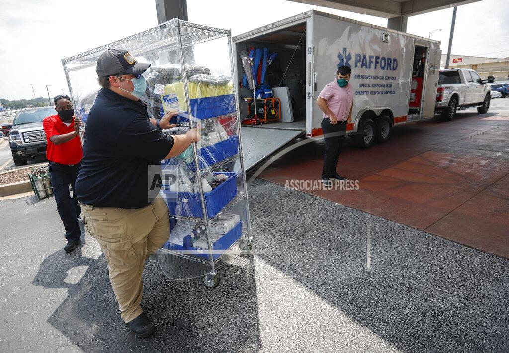 Andrew Jansen Ambulance crews unload equipment at the DoubleTree Hotel on Friday, July 23, 2021, in Springfield, Mo. The crews are part of a medical team that was sent to Springfield to help transport COVID-19 patients in the area. (Andrew Jansen/The Springfield News-Leader via AP)