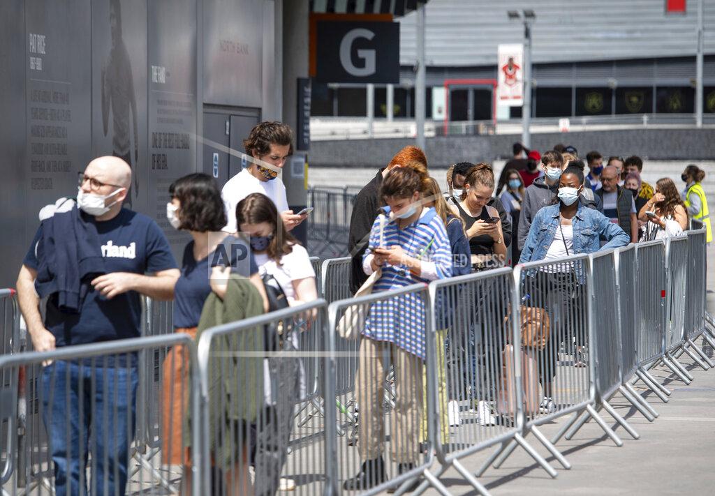 Dominic Lipinski People queue at a mass coronavirus vaccination centre held in Arsenal's Emirates Stadium, in north London, Friday June 25, 2021. (Dominic Lipinski/PA via AP)
