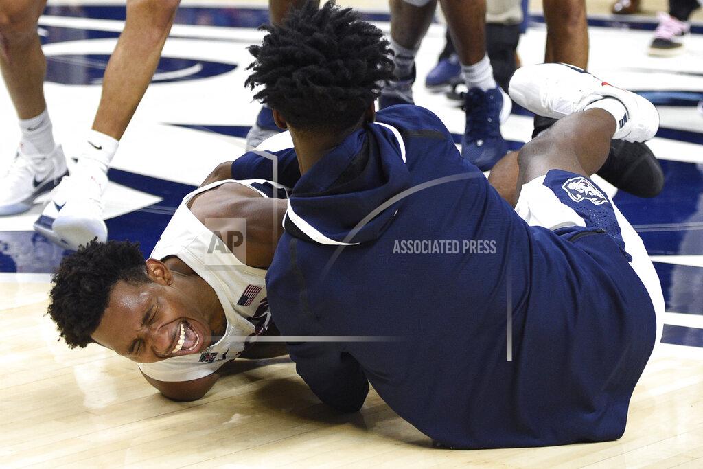 Jessica Hill Connecticut's Christian Vital, left, is pulled to the court and hugged by Connecticut's Temi Aiyegbusi, right, at the end of an NCAA college basketball game, Thursday, March 5, 2020, in Storrs, Conn. (AP Photo/Jessica Hill)