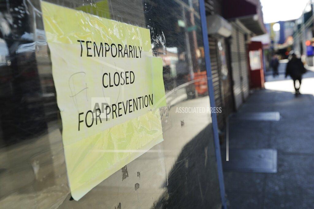 Frank Franklin Ii FILE - In this April 4, 2020, file photo, pedestrians pass closed stores on Roosevelt Avenue in the Queens borough of New York. The coronavirus crisis is upending service businesses, and the crisis may permanently change the way Americans work, shop and socialize, even after the disease fades away. (AP Photo/Frank Franklin II, File)