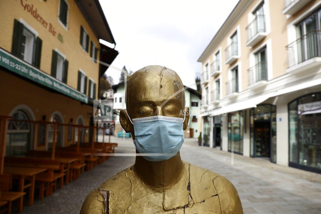 Matthias Schrader A art sculpture wearing a face mask in the deserted city of Berchtesgaden, Germany, Monday, Oct. 26, 2020. Authorities have posed the Berchtesgaden region under a lockdown since Oct. 20, 2020 due to a rising number of cases of the pandemic COVID-19 disease caused by the SARS-CoV-2 coronavirus in the district of Berchtesgadener Land. Local authorities in Bavaria's Rottal-Inn county, on the border with Austria, said Monday that the restrictions will begin at midnight. (AP Photo/Matthias Schrader)