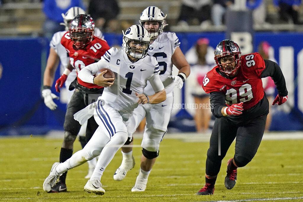 Rick Bowmer FILE - In this Saturday, Oct. 31, 2020, file pool photo, BYU quarterback Zach Wilson (1) carries the ball in the first half of an NCAA college football game against Western Kentucky in Provo, Utah. An unusual college football season has produced some unexpected unbeaten teams dotting the AP Top 25 with about a month left. Led by No. 7 Cincinnati and No. 8 BYU, five teams from outside the Power Five conferences have yet to lose. (AP Photo/Rick Bowmer, Pool, File)