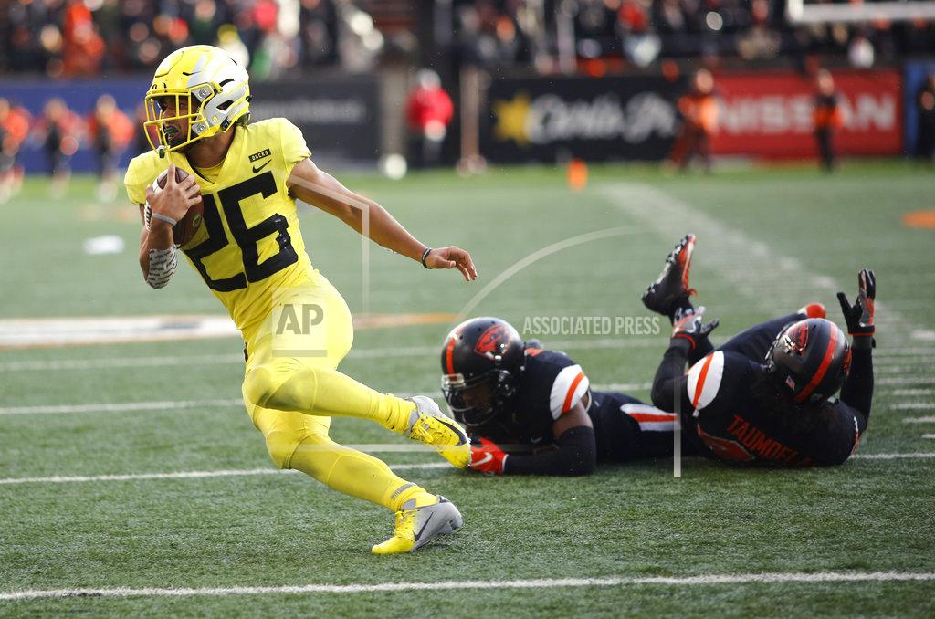 Timothy J. Gonzalez Oregon running back Travis Dye (26) leaves a pair of Oregon State defenders in his wake on a touchdown run during the second half of an NCAA college football game in Corvallis, Ore., on Friday, Nov. 23, 2018. Oregon won 55-15. (AP Photo/Timothy J. Gonzalez)