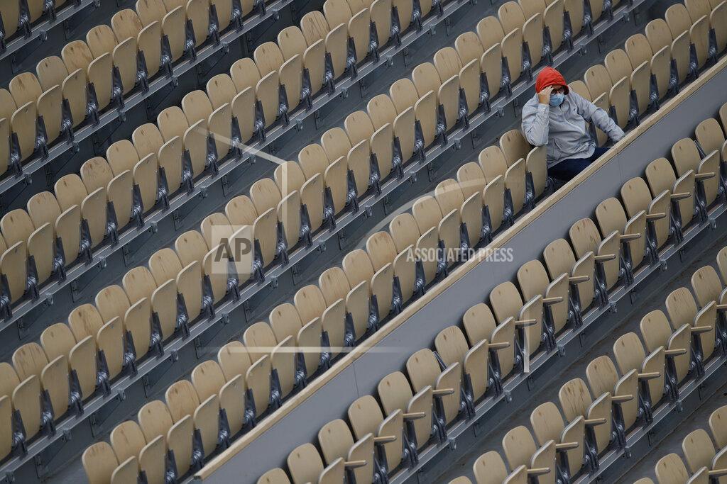 Christophe Ena A lone spectator watches Italy's Matteo Berrettini and Canada's Vasek Pospisil in the first round match of the French Open tennis tournament at Suzanne Lenglen court of the Roland Garros stadium in Paris, France, Tuesday, Sept. 29, 2020. (AP Photo/Christophe Ena)