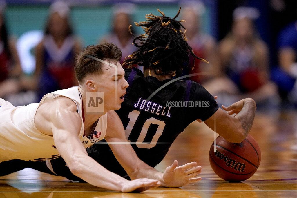 Charlie Riedel Kansas' Christian Braun, left, and Stephen F. Austin's Latrell Jossell (10) chase after a loose ball during the second half of an NCAA college basketball game Saturday, Dec. 18, 2021, in Lawrence, Kan. (AP Photo/Charlie Riedel)