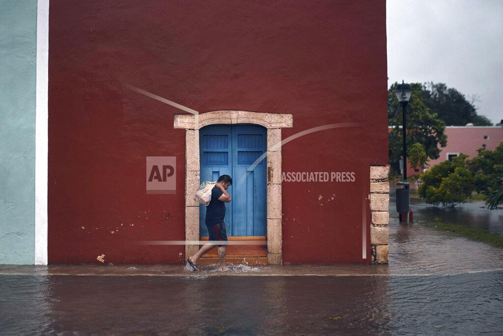 Andres Kudacki A man walks along a flooded street during Hurricane Delta in Valladolid, Mexico, Wednesday, Oct. 7, 2020. Hurricane Delta made landfall Wednesday just south of the Mexican resort of Cancun as a Category 2 storm, downing trees and knocking out power to some resorts along the northeastern coast of the Yucatan Peninsula. (AP Photo/Andres Kudacki)