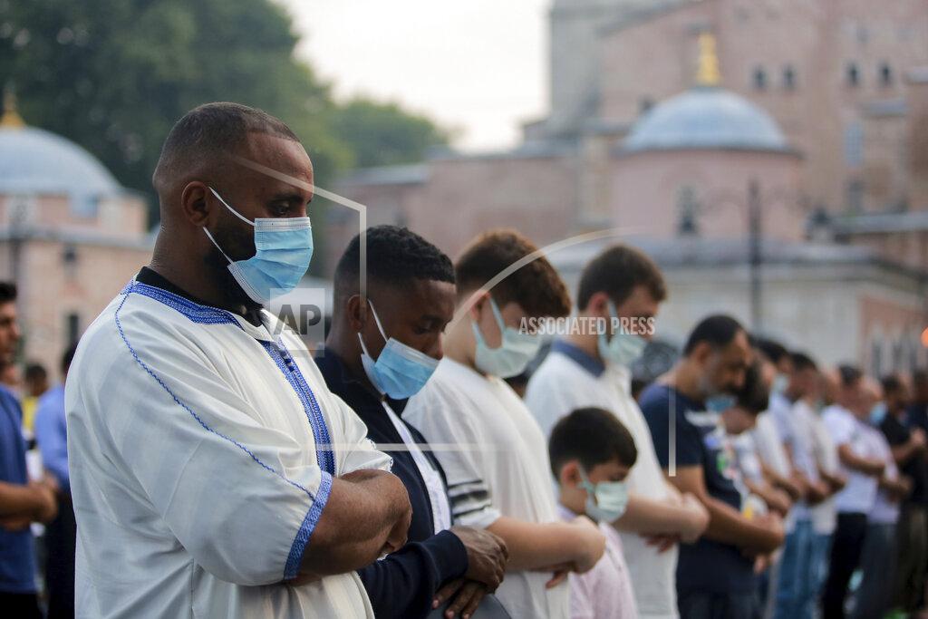 Mucahid Yapici Muslims offer prayers during the first day of the Eid al-Adha, outside the iconic Haghia Sophia mosque in the historic Sultan Ahmed district of Istanbul, Tuesday, July 20, 2021. The major Muslim holiday, at the end of the hajj pilgrimage to Mecca, is observed around the world by believers and commemorates prophet Abraham's pledge to sacrifice his son as an act of obedience to God. (AP Photo/Mucahid Yapici)