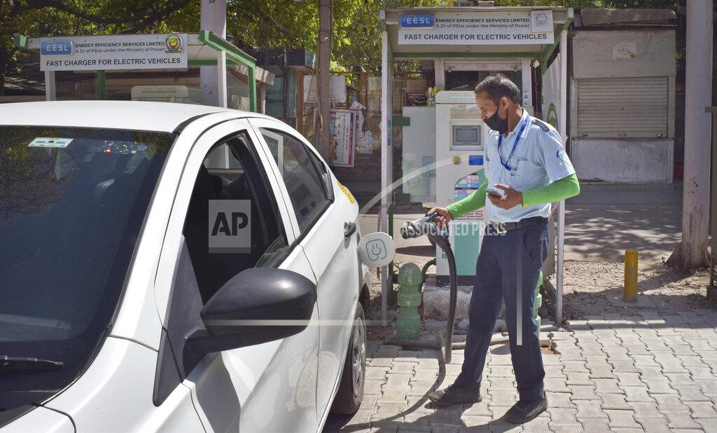 Neha Mehrotra A driver of an electric car charges his vehicle at public charging station in New Delhi, India, Thursday, April 1, 2021. India has ambitions to expand use of electric vehicles to wean itself from polluting fossil fuels, but EVs are still a rarity on its congested highways. A lack of charging stations and poor quality batteries are discouraging drivers from switching over. (AP Photo/Neha Mehrotra)