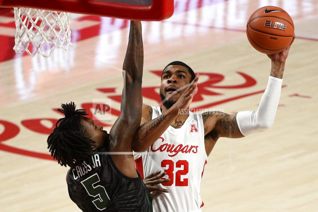 Eric Christian Smith Houston forward Reggie Chaney (32) shoots as Tulane forward Kevin Cross defends during the second half of an NCAA college basketball game, Saturday, Jan. 9, 2021, in Houston. (AP Photo/Eric Christian Smith)