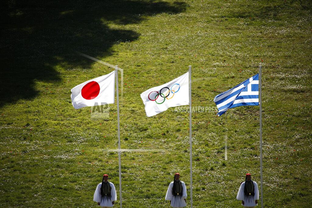 Yorgos Karahalis Greek Evzones guards stand next to Japan, Olympic and Greece flags, from left, during the flame lighting ceremony at the closed Ancient Olympia site, birthplace of the ancient Olympics in southern Greece, Thursday, March 12, 2020, 2020. Greek Olympic officials are holding a pared-down flame-lighting ceremony for the Tokyo Games due to concerns over the spread of the coronavirus. Both Wednesday's dress rehearsal and Thursday's lighting ceremony are closed to the public, while organizers have slashed the number of officials from the International Olympic Committee and the Tokyo Organizing Committee, as well as journalists at the flame-lighting. (AP Photo/Yorgos Karahalis)