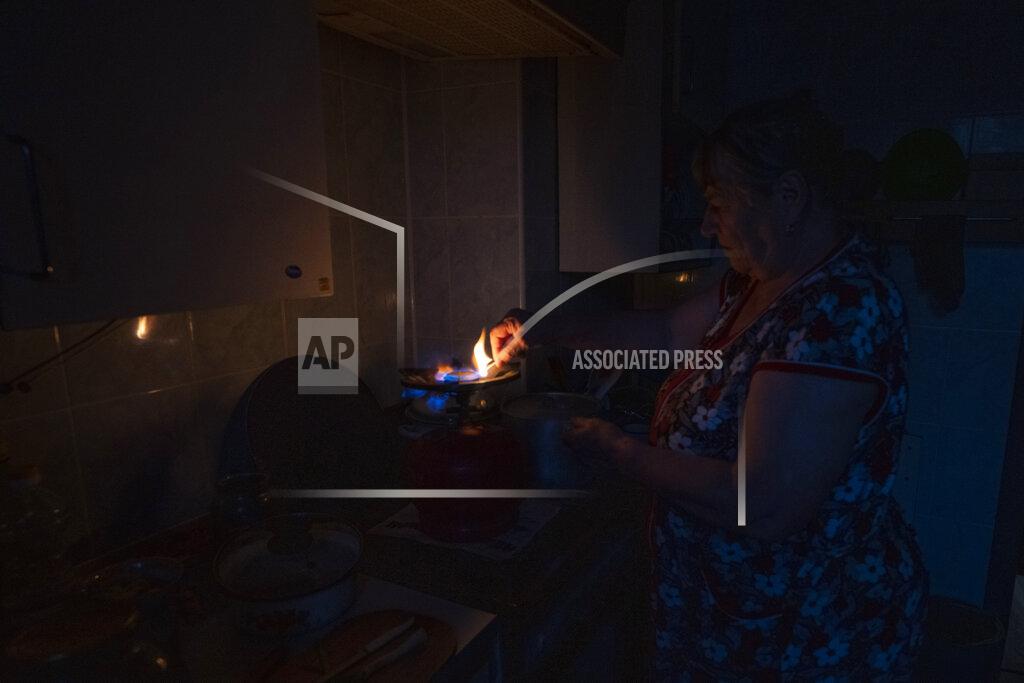 Nariman El-Mofty 70-year-old Valentyna Klymenko, who lives alone in her war-damaged building from Russian aerial bombs, lights her portable gas stove, in Borodyanka, Kyiv region, Ukraine, Tuesday, June 28, 2022. Then Klymenko returns, alone, to an apartment that used to be noisy and full of life. Now, instead of the voices of her great-grandchildren, she is greeted by dim, damp rooms. She rarely cooks. She drinks fruit compote and eats canned tomatoes, which she prepared last year, so as not to waste the gas in her portable stove. (AP Photo/Nariman El-Mofty)