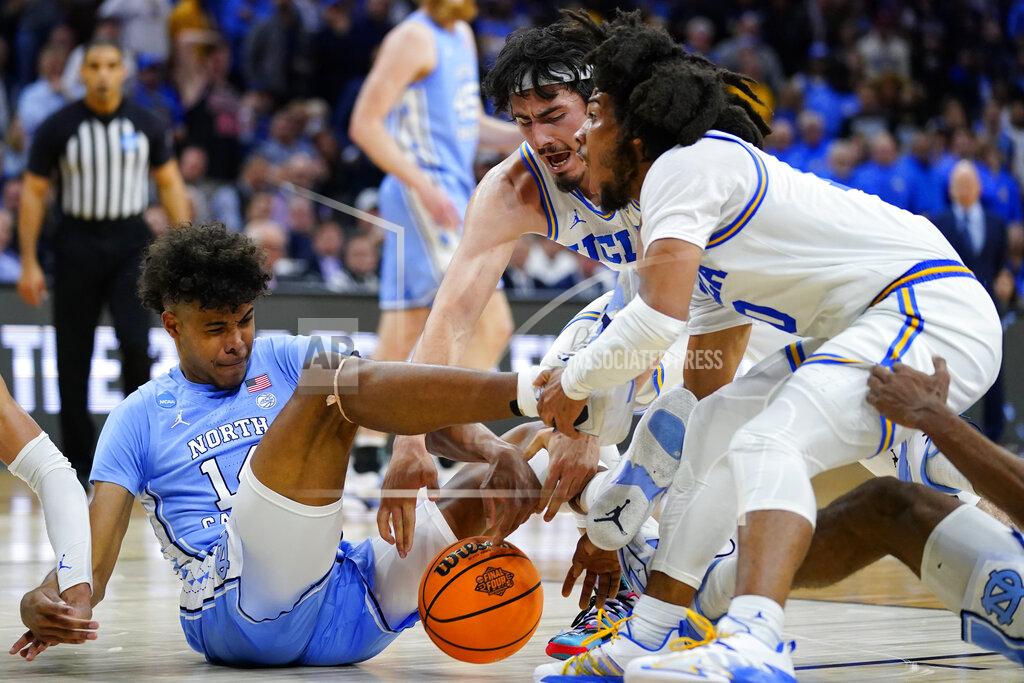 Matt Rourke North Carolina's Puff Johnson, left, battles for a loose ball against UCLA's Jaime Jaquez Jr., center, and Tyger Campbell during the second half of a college basketball game in the Sweet 16 round of the NCAA tournament, Friday, March 25, 2022, in Philadelphia. (AP Photo/Matt Rourke)