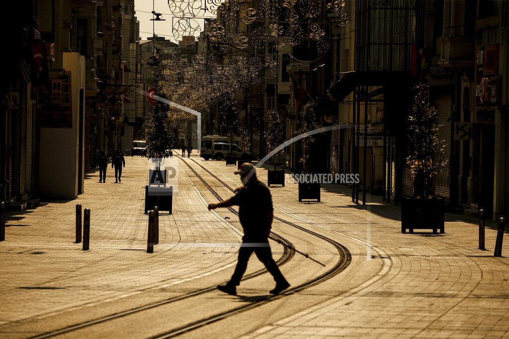 Emrah Gurel A man walks in the normally crowded but now mostly deserted Istiklal Street hours after the two-day curfew declared by the government to slow coronavirus spread, in Istanbul, Saturday, April 11, 2020. The new coronavirus causes mild or moderate symptoms for most people, but for some, especially older adults and people with existing health problems, it can cause more severe illness or death.(AP Photo/Emrah Gurel)