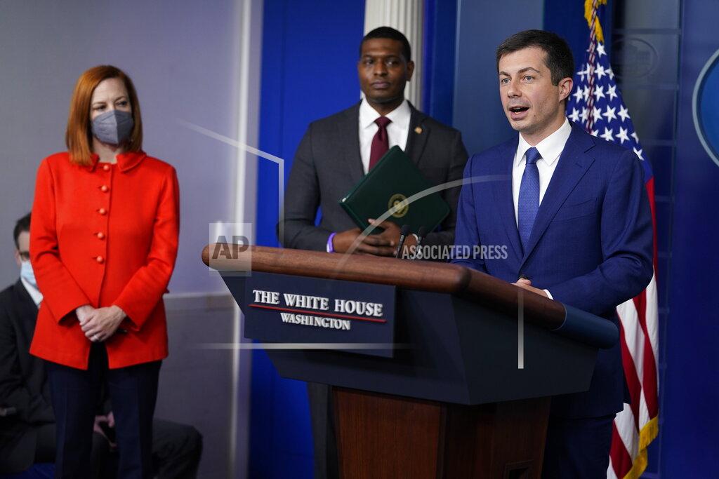 Evan Vucci Secretary of Transportation Secretary Pete Buttigieg listens during a press briefing at the White House, Wednesday, May 12, 2021, in Washington. White House press secretary Jen Psaki and Environmental Protection Agency Administrator Michael Regan look on. (AP Photo/Evan Vucci)