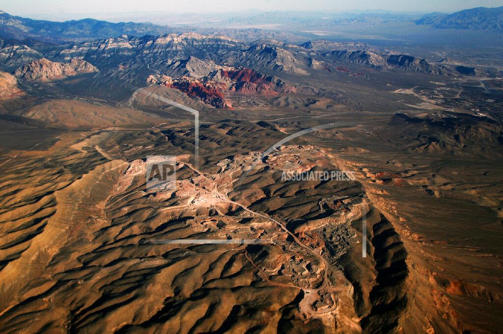 L.E. Baskow FILE - In this Oct. 11, 2016 photo, a gypsum mine owned by developer Jim Rhodes, who wants to develop housing on the site, is seen in the foreground while the Red Rock Canyon National Conservation Area is seen in the distance. Despite drought, cities in the U.S. West expect their populations to grow considerably in the coming decades. From Phoenix to Boise, officials are working to ensure they have the resources, infrastructure and housing supply to meet growth projections. In certain parts of the region, their efforts are constrained by the fact that sprawling metro areas are surrounded by land owned by the federal government. U.S. Sen. Catherine Cortez Masto wants to remedy the issue in Las Vegas by strengthening protections for some public lands while approving the sale of others to commercial and residential developers. (L.E. Baskow/Las Vegas Sun via AP, File)