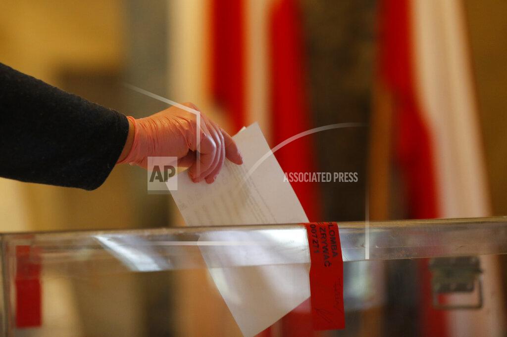 Petr David Josek A resident, wearing protective gloves, casts a vote during presidential election in Warsaw, Poland, Sunday, June 28, 2020. The election will test the popularity of incumbent President Andrzej Duda who is seeking a second term and of the conservative ruling party that backs him. (AP Photo/Petr David Josek)