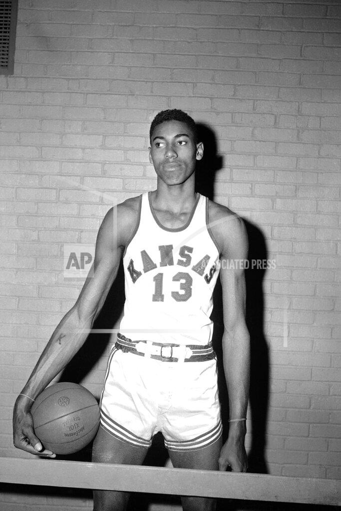 Anonymous FILE - This is a March 1, 1957, file photo showing Kansas college basketball player Wilt Chamberlain posed in Allen Field House in Lawrence, Kan. UNC sure made things interesting to win its first NCAA title. After a triple-overtime win against Michigan State in the semifinals, the unbeaten and top-ranked Tar Heels played three more overtimes in a 54-53 win against Wilt Chamberlain and Kansas in the NCAA championship game in the Jayhawks’ backyard of Kansas City, Missouri. (AP Photo/File)