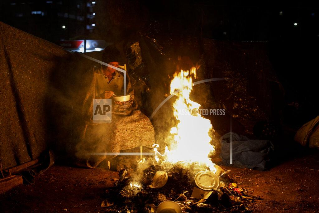 Marcelo Chello A homeless person sits by a fire amid historically cold weather in Sao Paulo, Brazil, late Thursday, July 29, 2021. The Brazilian government's meteorological institute says low temperatures should endure until the start of August. (AP Photo/Marcelo Chello)