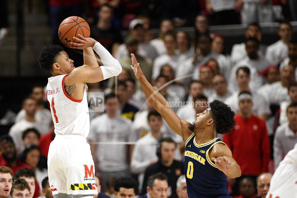 Nick Wass Maryland guard Anthony Cowan Jr. (1) shoots next to Michigan guard David DeJulius (0) during the first half of an NCAA college basketball game, Sunday, March 8, 2020, in College Park, Md. (AP Photo/Nick Wass)