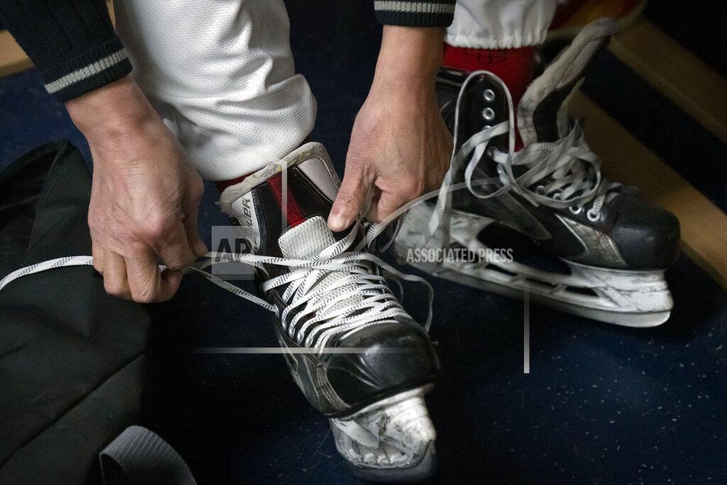 Mark Schiefelbein A member of the "1979" hockey club laces up his skates in the locker room before a match at a hockey rink in Beijing, Wednesday, Jan. 12, 2022. Spurred by enthusiasm after China was awarded the 2022 Winter Olympics, the members of a 1970s-era youth hockey team, now around 60 years old, have reunited decades later to once again take to the ice. (AP Photo/Mark Schiefelbein)