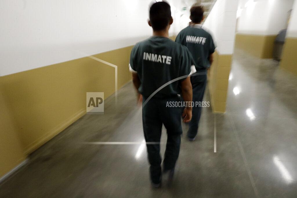 Gregory Bull Inmates walk down a hallway at the Otay Mesa Detention Center Wednesday, Aug. 23, 2017, in San Diego. The facility was at the center of the first big novel coronavirus outbreak at a U.S. immigration detention center in April 2020. (AP Photo/Gregory Bull)