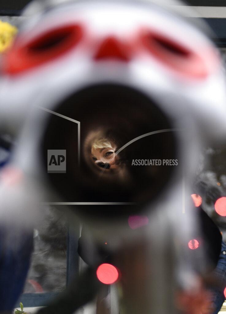Michael Perez Carol McCarthy looks down the candy chute that she will use to give out treats to socially-distant trick-or-treaters on Halloween, Monday, Oct. 26, 2020, in Palmyra, N.J. (AP Photo/Michael Perez)
