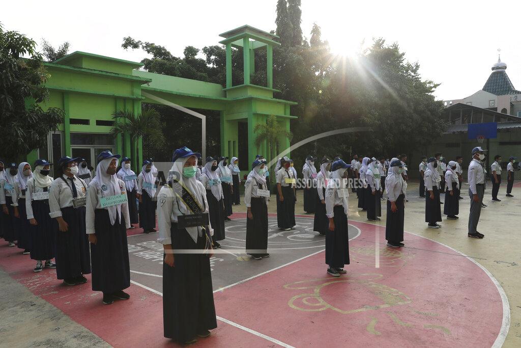 Achmad Ibrahim Students wearing face masks as a precaution against the new coronavirus line up at their school during the first day of reopening of state high schools in Bekasi on the outskirts of Jakarta, Indonesia, July 13, 2020. (AP Photo/Achmad Ibrahim)