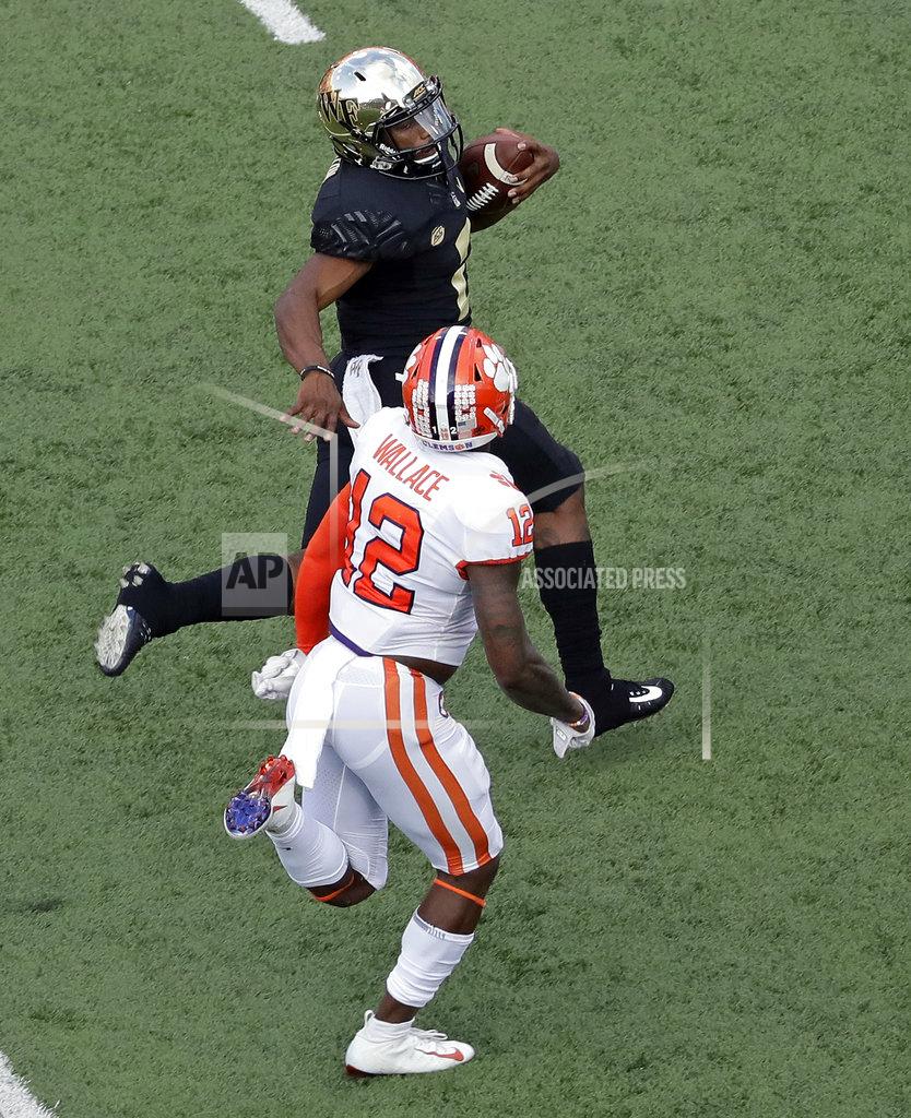 Chuck Burton Wake Forest's Kendall Hinton, top, runs for a long gain as Clemson's Christian Wilkins, bottom, pursues during the second half of an NCAA college football game in Charlotte, N.C., Saturday, Oct. 6, 2018. (AP Photo/Chuck Burton)